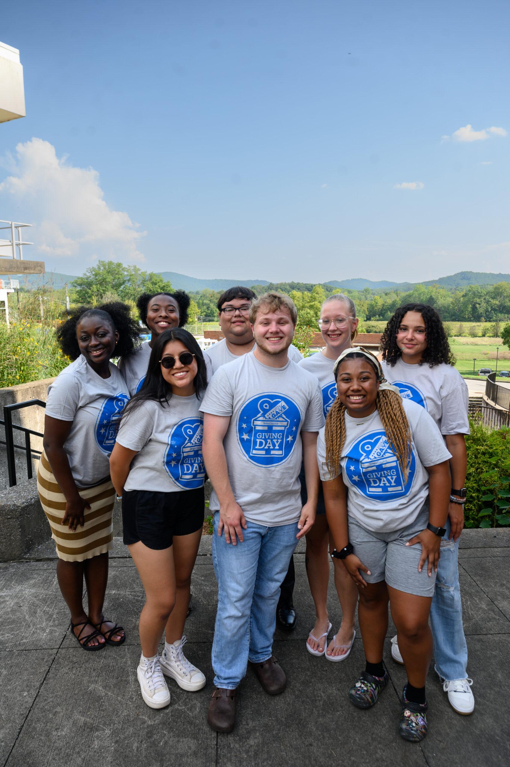 A group of Berea students are posing, smiling at the camera on the Alumni Fields patio.